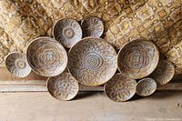 Front view of metal floral wall décor showing eleven embossed plates