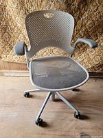 Front view of Herman Miller Caper chair showing perforated back, mesh seat, armrests, casters