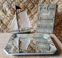 Overall lot showing sailboat decor, mirrored tray, and wooden sign together
