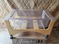 Overall view of sensory table showing clear plexiglass tub in wooden frame on casters