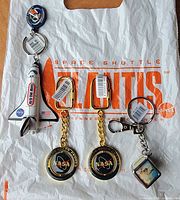 Overview of all four NASA Kennedy Space Center keychains on Atlantis bag