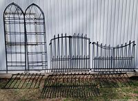 All seven metal garden pieces lined against wall for scale