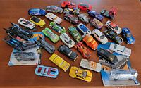 Entire lot of loose and carded Hot Wheels cars spread on table