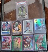 All nine cards laid out including PSA slab and eight sleeved cards