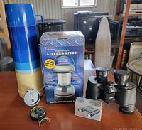 Group shot of lantern box, thermos, binoculars, compass and knife box