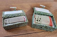 Both soapstone seals in their green brocade boxes, lids open