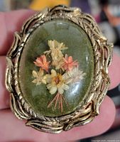 Front view showing domed glass and dried flower arrangement
