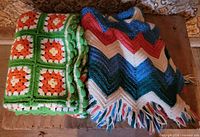 Both crocheted blankets folded side by side