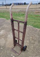 Front view of metal hand truck showing frame, handles, and wheels