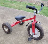 Side view of red Yerf-Dog tricycle showing full frame, wheels, seat, pedals