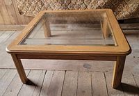 Coffee table front angle showing wood frame and glass top
