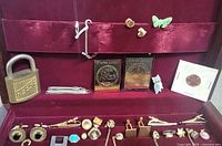 Interior lid with padlock, nail clipper, Staffa stamps, pins, coin, cufflinks visible