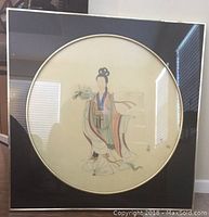 Framed Chinese silk painting featuring a woman holding a lotus flower, with colorful traditional robes on a cream background.