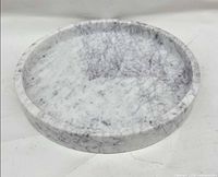 Top view of white marble tray showing gray veining and low rim