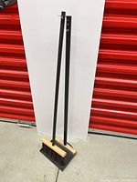 Full view of broom and dustpan standing together
