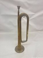 Full view of brass bugle with mouthpiece attached