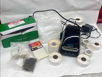 Overview of printer, label rolls, Uline box, label sheet pack, loop fasteners