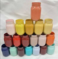 Front view of 21 painted Bernardin mason jars stacked in pyramid, showing full colour assortment
