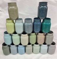 Front view of stacked painted jars showing full colour range and embossing