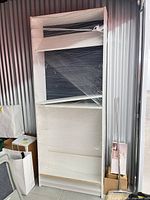 Full view of tall white Billy bookcase wrapped in plastic