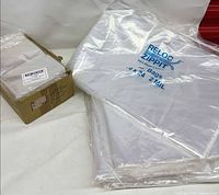 Stacks of large Reloc Zippit 18 x 24 in bags and Uline carton visible