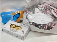 Blue Air Synmax glove box, Smoothlyss glove box, bag of individually wrapped 3M Aura 1870+ respirators