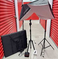 Softbox lighting kit with two stands, one assembled softbox, Pivo tripod, folded photo studio box and accessories