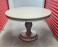 Full view of round pedestal dining table showing top and base
