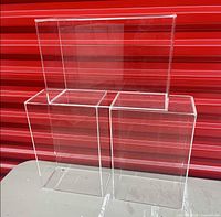 Three clear acrylic cubes on table against red backdrop