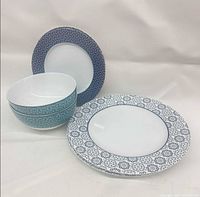 Six ceramic pieces: two bowls, two dinner plates, two salad plates with patterned rims