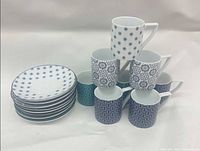 Stack of patterned saucers beside matching cups