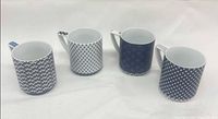 Four assorted blue and white porcelain mugs side by side