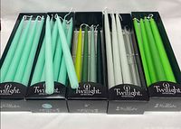 Five open Twilight boxes showing assorted green taper candles