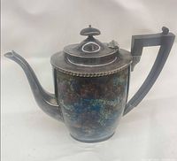 Left side view showing overall form, handle, spout and patina