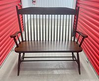 Front view of dark mahogany Windsor spindle-back bench