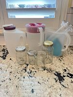 Group shot of pitchers, jars, bottle and tumblers on countertop
