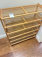 Front angled view of assembled bamboo shoe rack showing four slatted tiers and natural finish