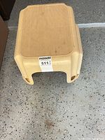 Overall view of beige plastic step stool showing size, color, design and condition