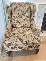 Front view of wingback armchair showing upholstery pattern and front legs