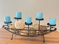 Overall view of metal candle holder with candles and rattan balls displayed