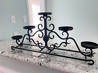 Full view of black metal candelabra on countertop