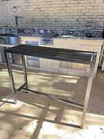 full view of charcoal steel console table showing frame and slatted top