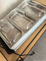 Top view of buffet server showing three clear lids and pans