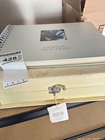 Scrapbook album atop keepsake box showing cover design and latch