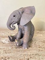 Front view of seated gray porcelain elephant figurine