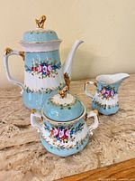 Coffee/tea pot, sugar bowl and creamer showing pattern and condition