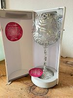 Wine glass inside open display box showing glitter swirl and coloured accents