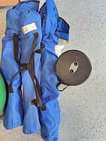 three blue carry bags containing folding chairs and black collapsible stool