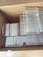 Box containing multiple clear acrylic storage bins of various sizes