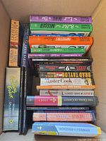 Top-down view of first box showing mix of fiction titles by Osman, Berry, Baldacci alongside cookbooks and other paperbacks